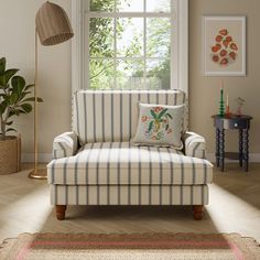 a striped chair in front of a window with potted plants on the side table