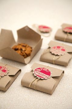 some brown paper bags with pink tags on them and cookies in the middle one is empty