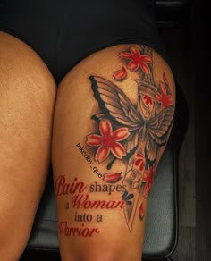 a woman's thigh with tattoos and flowers on her thighs, sitting next to a piece of luggage