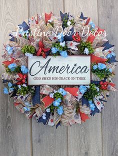 an american wreath with the words god shed his grace on thee written in red, white and blue