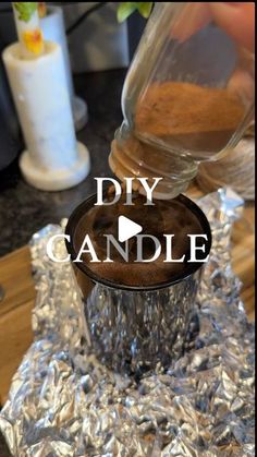 someone is pouring something into a cup on tin foil with the words diy candle above it