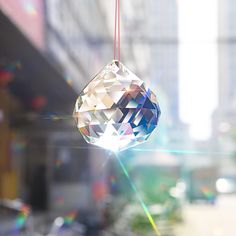 an ornament hanging from a string in front of a city street with buildings