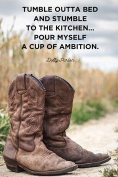 a pair of brown cowboy boots sitting on top of a dirt road with a quote about tumble outa bed and stumble to the kitchen pour mysel a cup of ambition