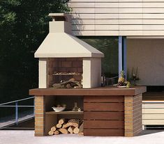 an outdoor bbq grill with wood stacked on the side and firewood in front