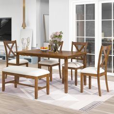 a dining room table with four chairs and a bench in front of a tv set