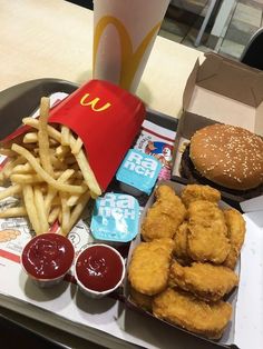 a tray that has some food on it and a cup with ketchup next to it