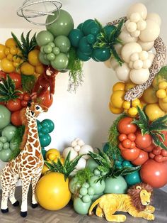 a giraffe surrounded by balloons and fruits in the shape of a letter o