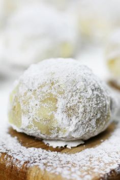 powdered sugar covered pastry sitting on top of a wooden cutting board