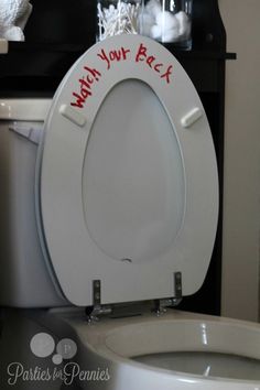 a white toilet sitting in a bathroom next to a trash can with writing on it