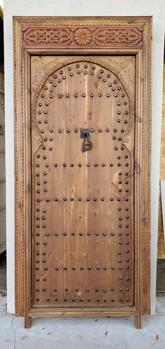 an ornate wooden door with metal studs on the front and side doors are shown