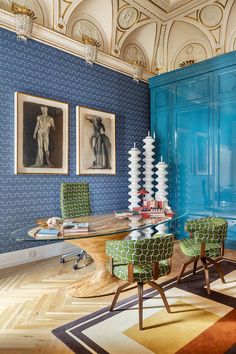 a living room with blue walls and green chairs