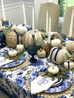 a blue and white table setting with pumpkins