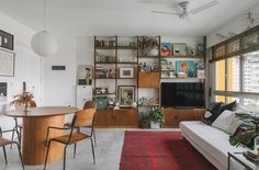 a living room filled with furniture and a flat screen tv sitting on top of a wooden shelf