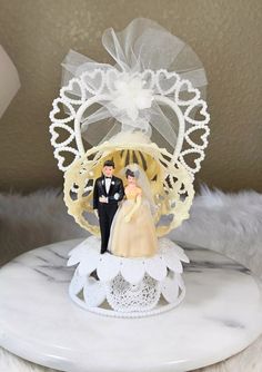 a wedding cake topper with a bride and groom on it