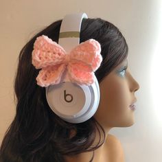 a headphone with a pink bow on it's ear sitting on top of a mannequin