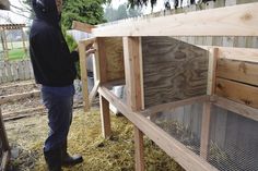 a man standing next to a chicken coop