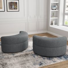 two grey chairs sitting on top of a rug