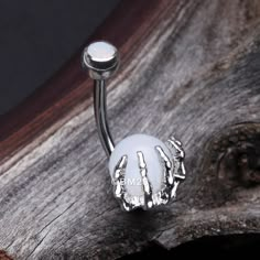 a white glass ball with skeleton hands is mounted on a metal barbell clicker