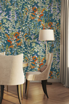 two chairs and a lamp in front of a floral wallpaper