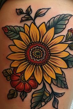 a sunflower tattoo on the back of a woman's thigh, with leaves and flowers