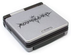 a silver and black game boy advance is on the white surface with an arrow drawn on it's side