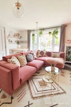 a living room with pink couches and rugs in front of a window on the wall