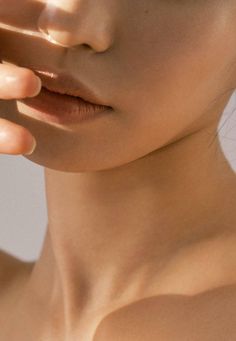 a close up of a woman with her hand on her face and one eye open