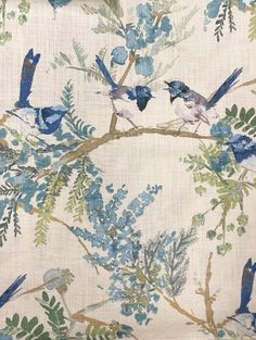 blue birds are sitting on the branches of a tree