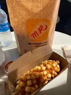 a box filled with food sitting on top of a table next to a paper bag