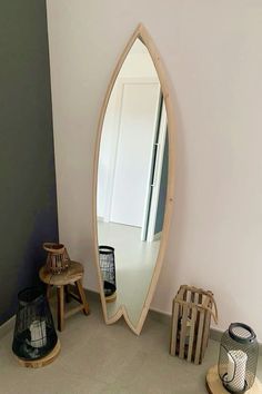 a mirror sitting on top of a white wall next to two small tables and lamps