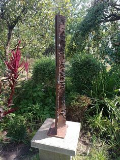 a metal sculpture sitting in the middle of a garden