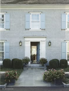 a house with white shutters and blue doors