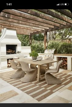 an outdoor dining area is shown with wood and stone furniture, as well as a fire pit