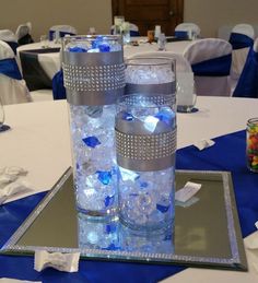 two tall vases filled with blue and white flowers on top of a silver tray