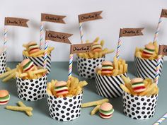 french fries and hamburgers in paper cups with name tags on them