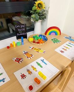 a wooden table topped with lots of toys and paper cut outs on top of it