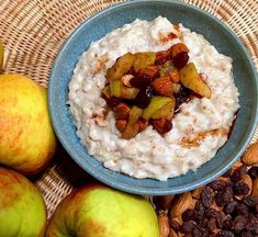 a bowl of oatmeal with apples and raisins on the side