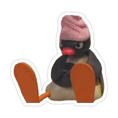 a penguin with a pink hat sitting on top of it's head and holding an orange paddle