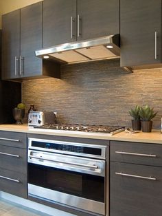 a modern kitchen with stainless steel appliances and wood cabinets