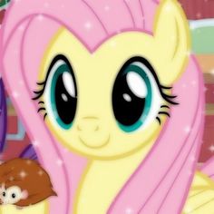 a pink pony with big eyes holding a small rodent in her hand and looking at the camera