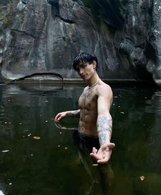 a shirtless man standing in the water