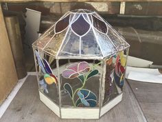 a stained glass lantern sitting on top of a wooden table