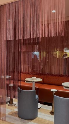 the inside of a restaurant with red curtains