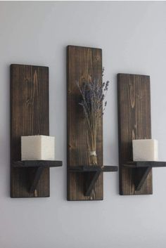 two wooden wall shelves with candles and some flowers on one shelf, the other is made out of wood