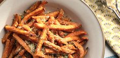 a white plate topped with french fries covered in seasoning