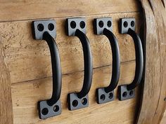 four black handles on a wooden door hangers in the shape of letters and numbers