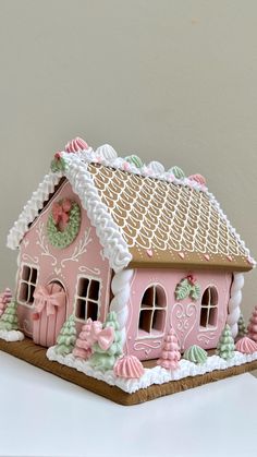 a pink gingerbread house is decorated with icing