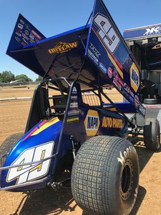 a blue race car sitting on top of a dirt field