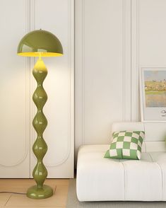 a green lamp sitting on top of a white couch