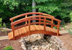 a wooden bridge over rocks in a park